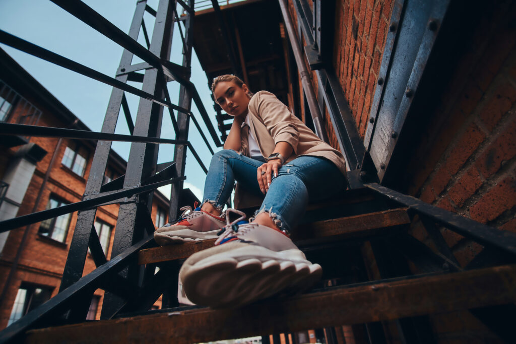 Low angle photo of a woman sitting on some stairs