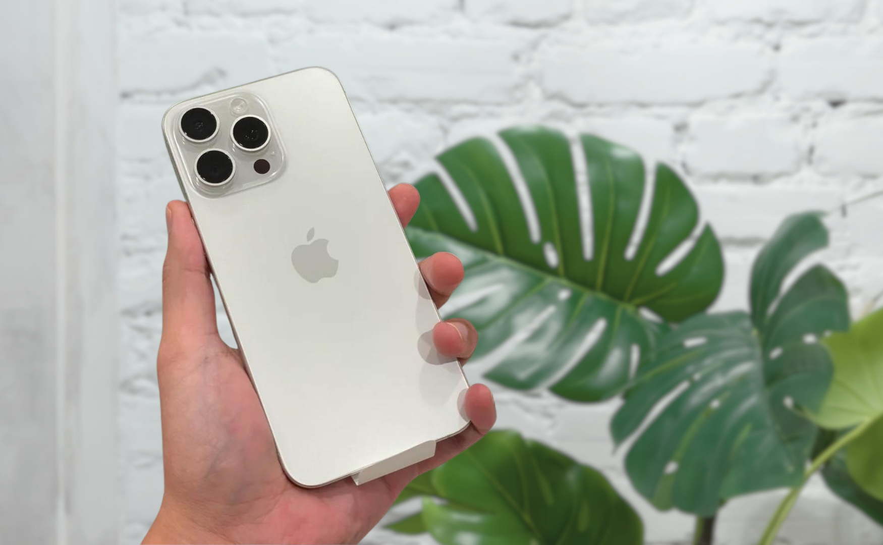 Iphone 15 pro colours: white titanium, hand holding phone
