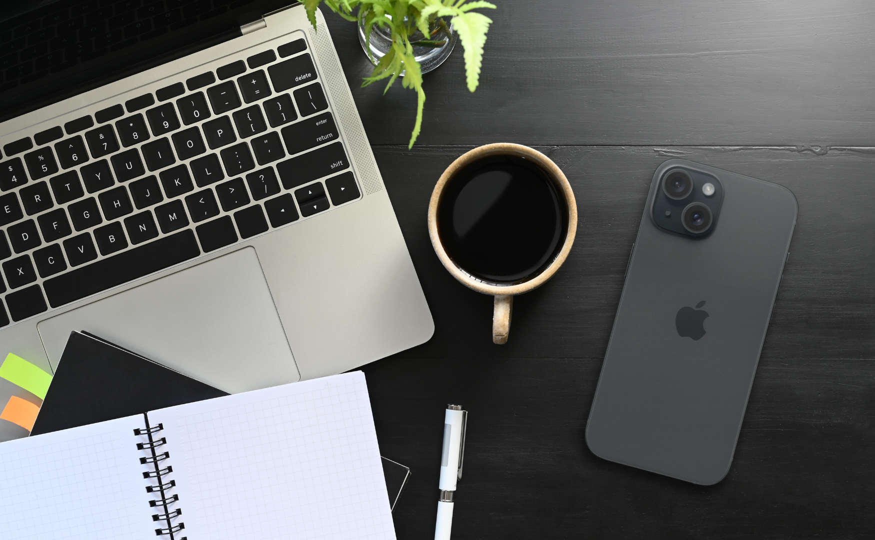 Iphone 15 midnight (black) on black desk