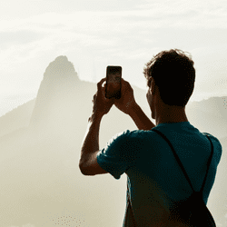 Are Refurbished Phones Worth It? Cost, Reliability &Amp; Performance Explained Man taking photo with refurbished phone