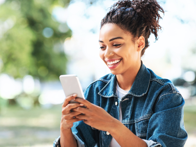 Fraud Prevention &Amp; Device Ownership Policy (For Trade Ins) Girl smiling looking at phone outdoors